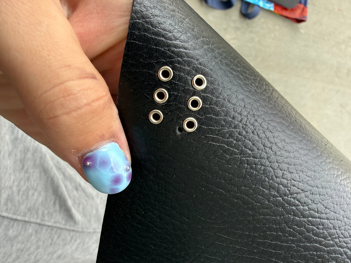 Close-up of minor scuffs and silver grommets on A5 pebbled black journal